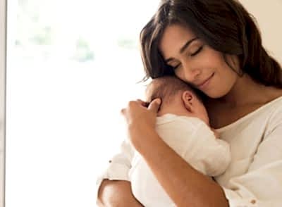 Pretty woman holding a newborn baby in her arms Pretty woman holding a newborn baby in her arms